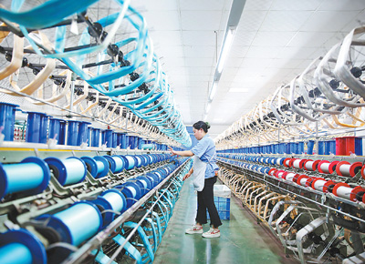工人在重庆市黔江区的丝绸生产车间络丝