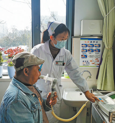 江苏省南京市栖霞区西岗社区卫生服务中心的护士在给患者检查肺功能。本报记者 尹晓宇摄