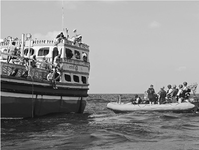 美军“杜威”号驱逐舰船员驾驶救生艇靠近遇险的伊朗渔船