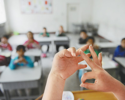 宁夏特殊教育学校,一位老师在课堂上用手语给聋哑孩子讲课.