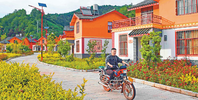 傈僳族楚雄图片:养马场村村民骑摩托车从村里穿过