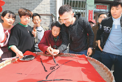 外国游客体验塘泾村村民蚕文化
