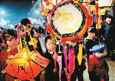 2月12日,江西上饶德兴市新岗山镇占才村的小朋友手提花灯闹