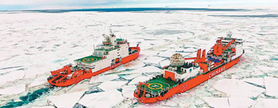 “雪龙2”号（左）破冰引领“雪龙”号向中国南极中山站靠近。新华社发