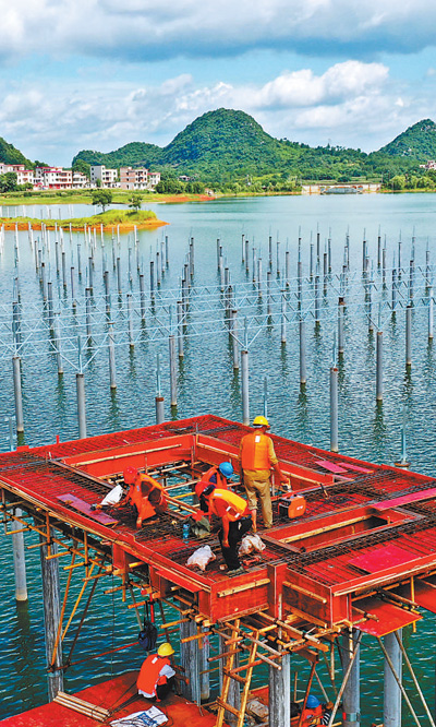 7月11日,湖南省郴州市嘉禾县千家洞水库,建设者顶着烈日加紧施工.