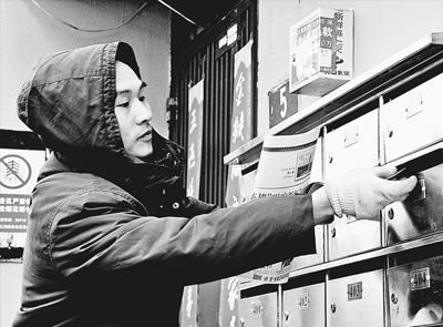 2月7日,上海共和新路邮局邮递员为居民投送订阅的报纸.
