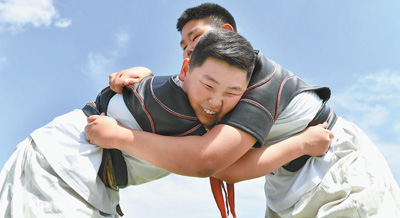 6月11日,两名学生在练习摔跤.